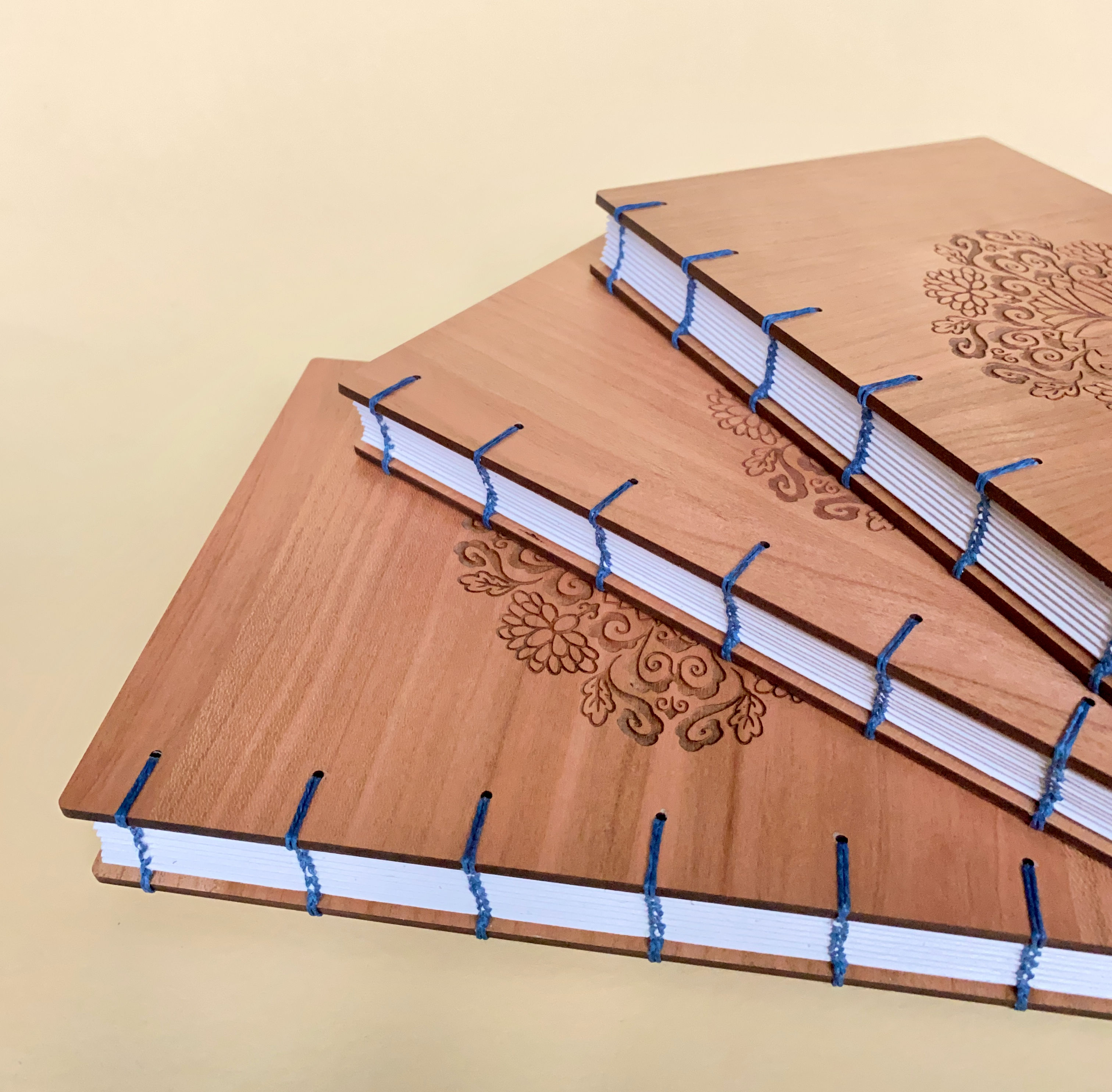 3 books I made to celebrate the life of a woman who passed away, to be given to her sisters and mother. The books are made from Cherry wood and bound with cobalt blue thread set against a pale yellow background.