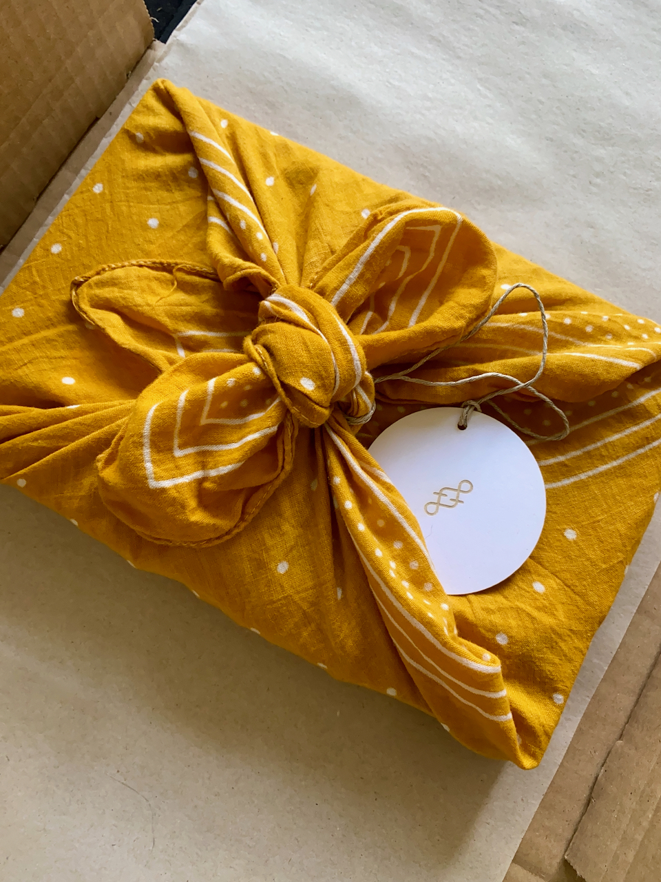 A fondfolio memory book wrapped in a mustard coloured vintage scarf.